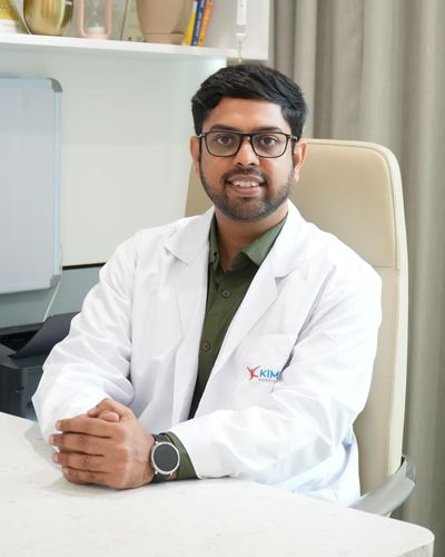 Dr. Suraga Belakawadi at his desk in the clinic